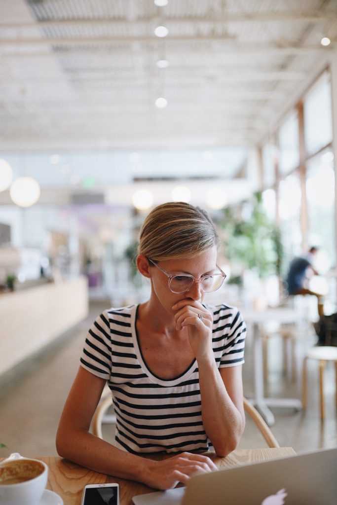 woman in black and white striped shirt sitting on chair